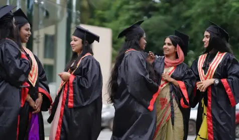 Female optometry students in graduation robes and caps, celebrating their achievement at Abate Institution